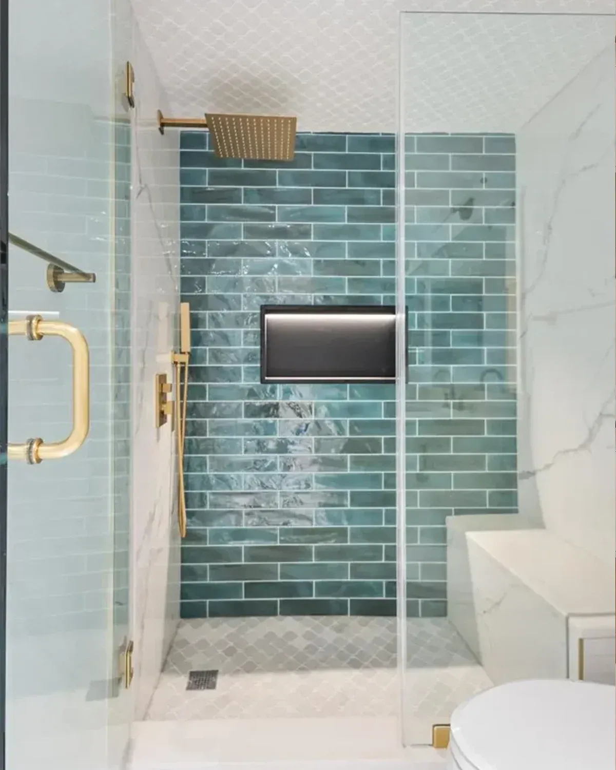 Shower with green glazed tile, brass handle and marble walls